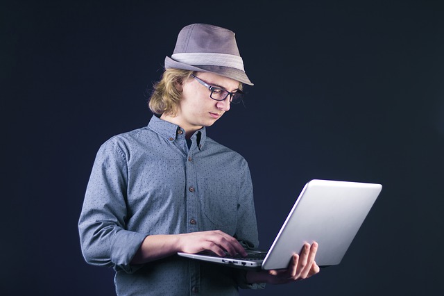 muž v klobouku s notebookem